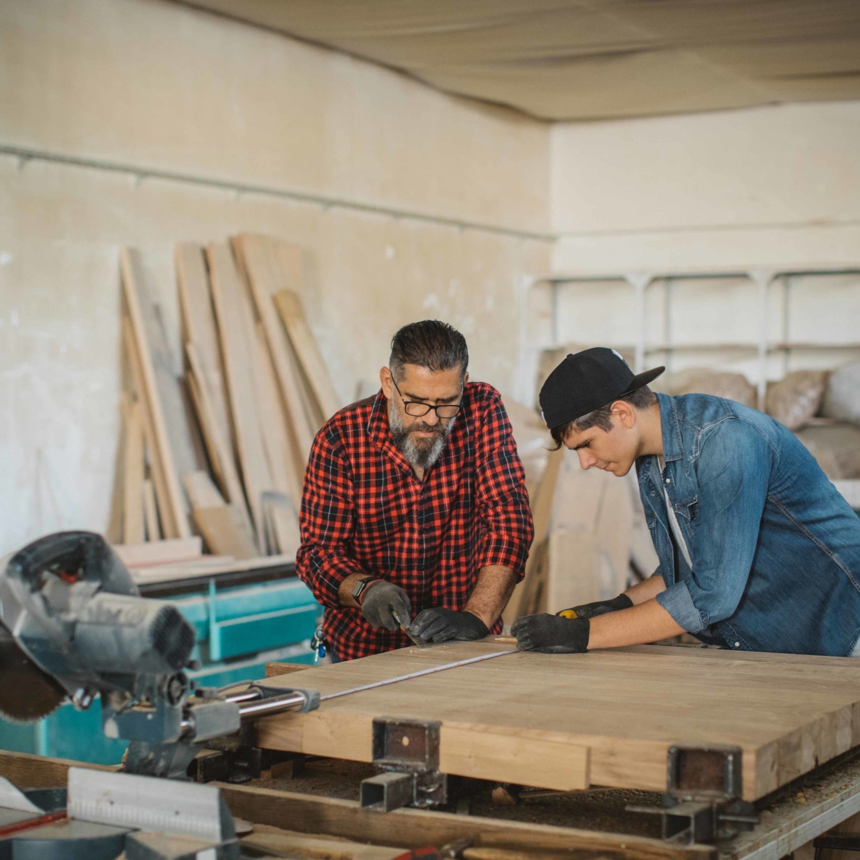 Father and son work together in a wood shop.