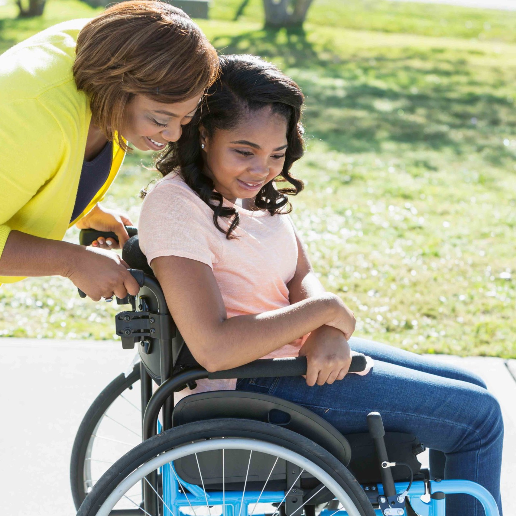 Mom Pushes Teenage Daughter in Wheelchair.