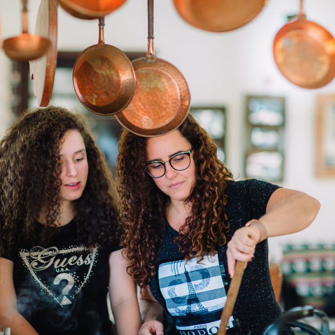 Mom and Daughter bond over cooking together in their kitchen.